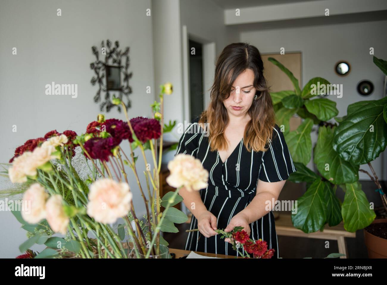 Femme tenant les tiges de fleurs et construisant l'arrangement floral Banque D'Images