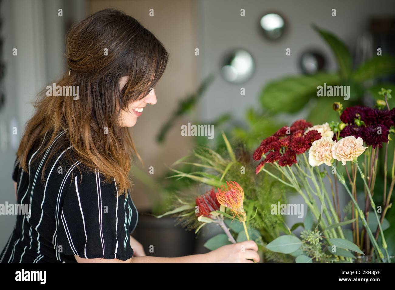 Profil latéral de femme assemblant bouquet Banque D'Images