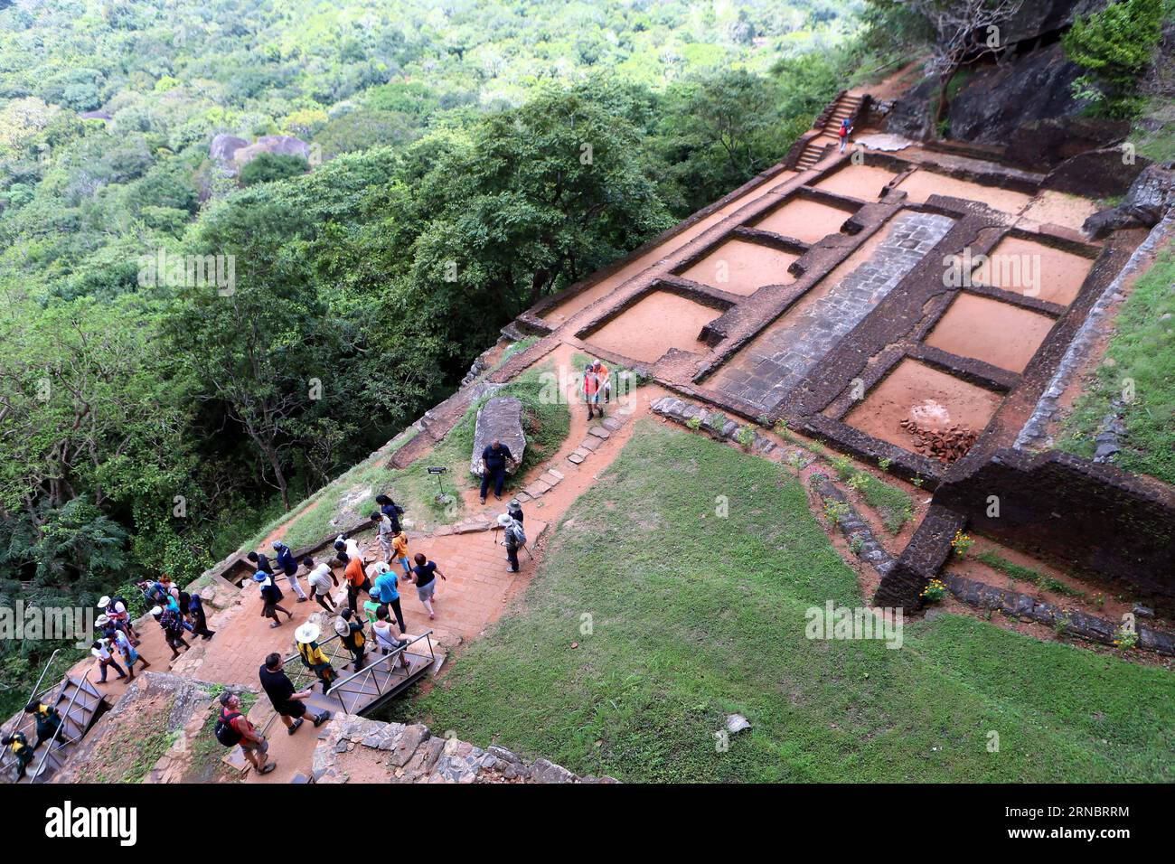 (160311) -- SIGIRIYA, le 11 mars 2016 -- des touristes visitent l'ancienne ville de Sigiriya, à quelque 170 km au nord-est de Colombo, capitale du Sri Lanka, le 8 mars 2016. Les ruines de la capitale construite par le roi parricide Kassapa I (AD477-495) se trouvent sur les pentes abruptes et au sommet d'un pic de granit s'élevant à environ 180m de haut. Une série de galeries et d’escaliers émergeant de la bouche d’un gigantesque lion contruté de briques et de plâtre donnent accès au site. L'ancienne ville de Sigiriya a été inscrite au patrimoine mondial par les organisations des Nations Unies pour l'éducation, la science et la culture (U Banque D'Images