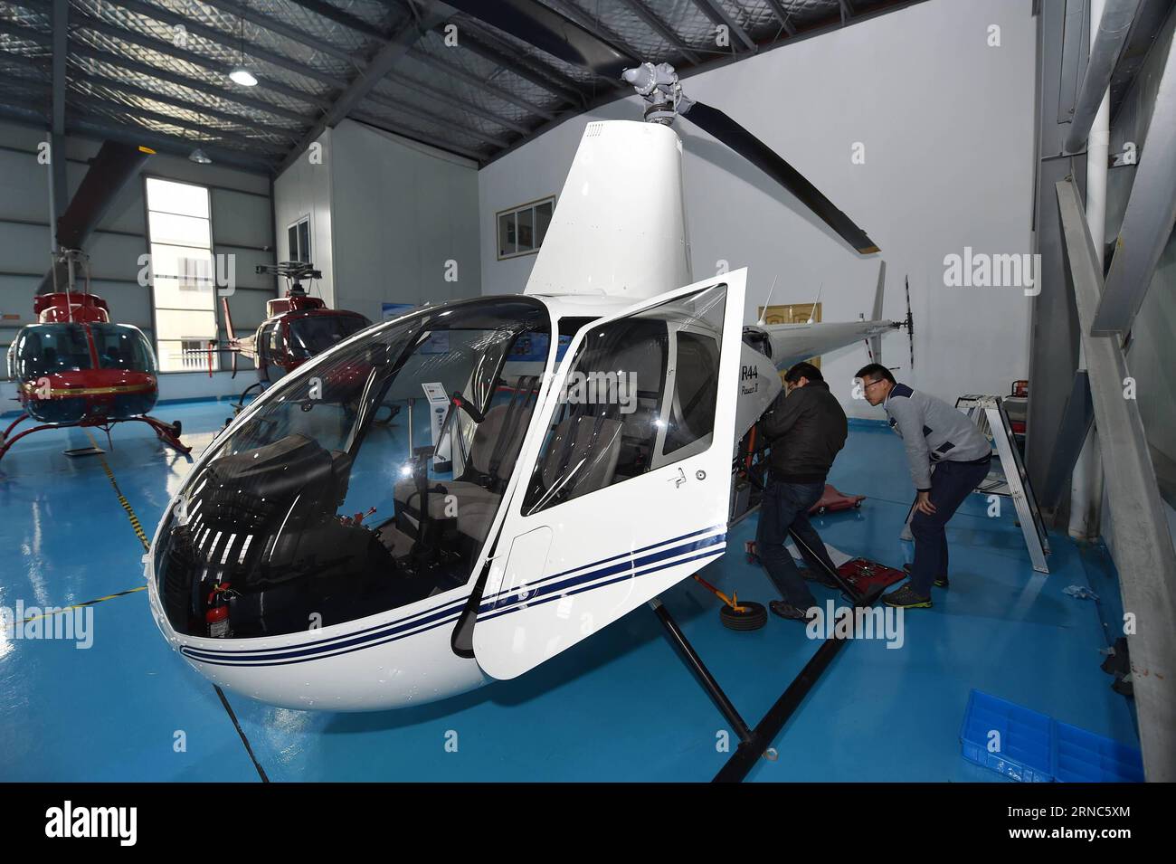 (160324) -- NINGBO, le 24 mars 2016 -- des techniciens entretiennent un hélicoptère Robinson RAVEN au centre Yida de Shanghai General Dynamic Aero Tech. Company (GDAT), un magasin 5S d'avions généraux, dans la zone portuaire bondée de Meishan à Ningbo, dans la province de Zhejiang de l'est de la Chine, le 23 mars 2016. Le magasin General Aircraft 5S, ouvert le 8 avril 2015, a vendu de loin 88 hélicoptères. Le magasin fournit plus de 20 types d'hélicoptères avec le prix de vente entre trois à 100 millions de yuans (461,400-15,38 millions de dollars américains). (lfj) CHINA-ZHEJIANG-NINGBO-AIRCRAFT STORE (CN) HuangxZongzhi PUBLICATIONx Banque D'Images