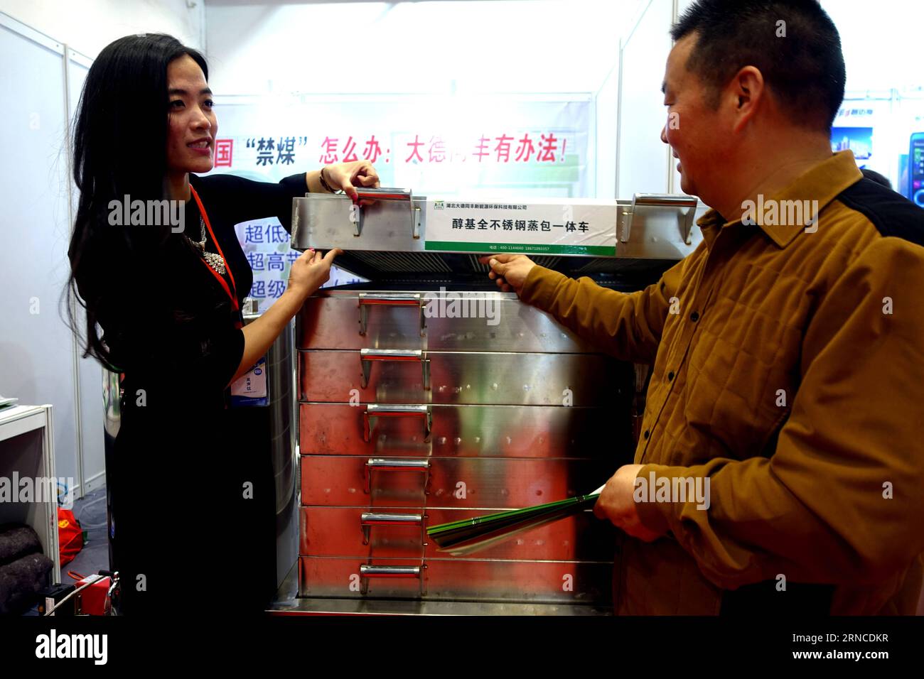 (160406) -- BEIJING, 6 avril 2016 -- Un visiteur (R) apprend à connaître un appareil de cuisson qui utilise de l'éco-carburant pour remplacer le charbon lors de la huitième exposition de l'industrie chinoise à faible teneur en carbone qui s'est tenue à Beijing, en Chine, le 6 avril 2016. L'événement de 3 jours a attiré près d'un millier d'entreprises et quelque 5000 produits dotés de nouvelles technologies, en mettant l'accent sur l'industrie à faible émission de carbone. (Zhs) CHINA-BEIJING-EXHIBITION-LOW CARBON (CN) PanxXu PUBLICATIONxNOTxINxCHN Beijing avril 6 2016 un visiteur FAIT connaissance avec un appareil de cuisson Thatcher utilise le carburant écologique pour remplacer le charbon À LA huitième Chine Low Carbon Industry Exhibition Hero à Beijing C. Banque D'Images