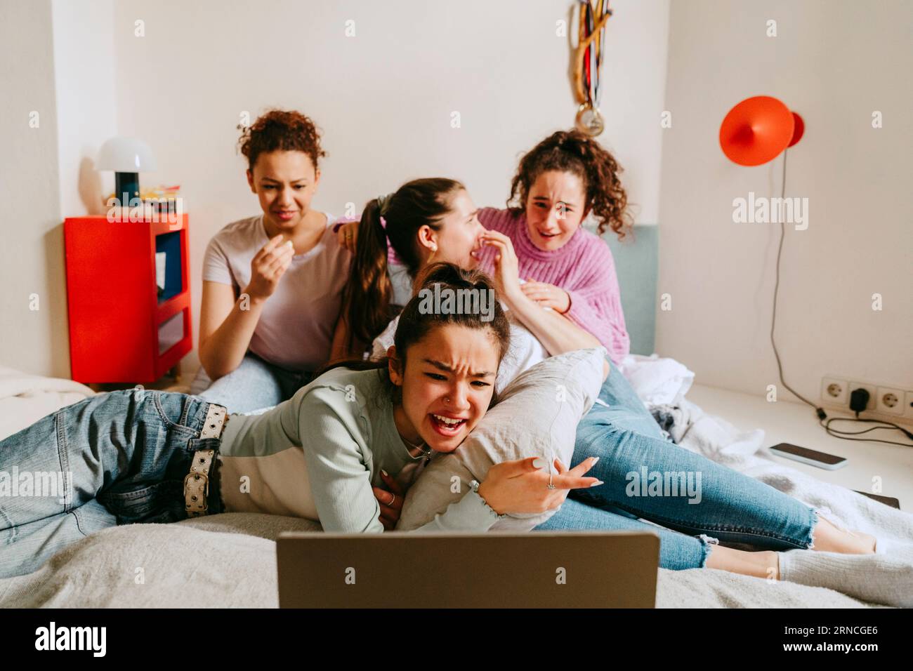 Amies femmes regardant un film ensemble à la maison Banque D'Images