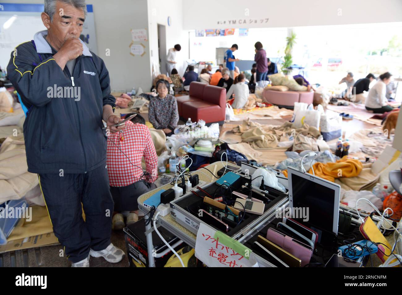 (160417) -- KUMAMOTO, April 17, 2016 -- A man recharges his cellphone at a shelter in the earthquake rocked Mashiki in Kumamoto prefecture, Japan, April 17, 2016. A powerful magnitude-7.3 earthquake struck the island of Kyushu in southwestern Japan early Saturday just a day after a sizable foreshock hit the region, with the number of fatalities now standing at 41 according to the latest figures on Sunday. ) (djj) JAPAN-KUMAMOTO-EARTHQUAKE-AFTERMATH MaxPing PUBLICATIONxNOTxINxCHN   160417 Kumamoto April 17 2016 a Man recharges His cellphone AT a Shelter in The Earthquake Rocked Mashiki in Kumam Banque D'Images