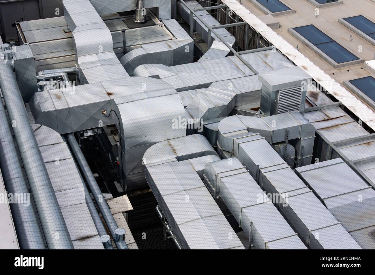 Conduits du système de ventilation et de climatisation sur le toit du bâtiment. La photo a été prise en lumière naturelle et douce. Vue d'en haut. Banque D'Images