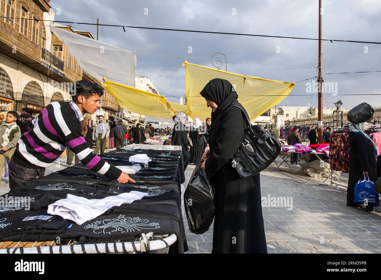 (160505) -- PÉKIN, 5 mai 2016 -- une photo prise le 19 janvier 2012 montre une femme ramassant des vêtements dans un marché de la vieille ville d'Alep, en Syrie. La citadelle d'Alep est un grand palais médiéval fortifié au centre de la vieille ville d'Alep. )(zhf) SYRIA-ALEPPO-FILE LixMuzi PUBLICATIONxNOTxINxCHN 160505 Pékin Mai 5 2016 fichier photo prise LE 19 2012 janvier montre une femme cueillant des vêtements DANS un marché dans la vieille ville d'Alep Syrie la Citadelle d'Alep EST un grand palais médiéval fortifié dans le centre de la vieille ville d'Alep zhf Syrie Alep dossier LiXMuzi PUBLICATIONxNOTxINxCHN Banque D'Images