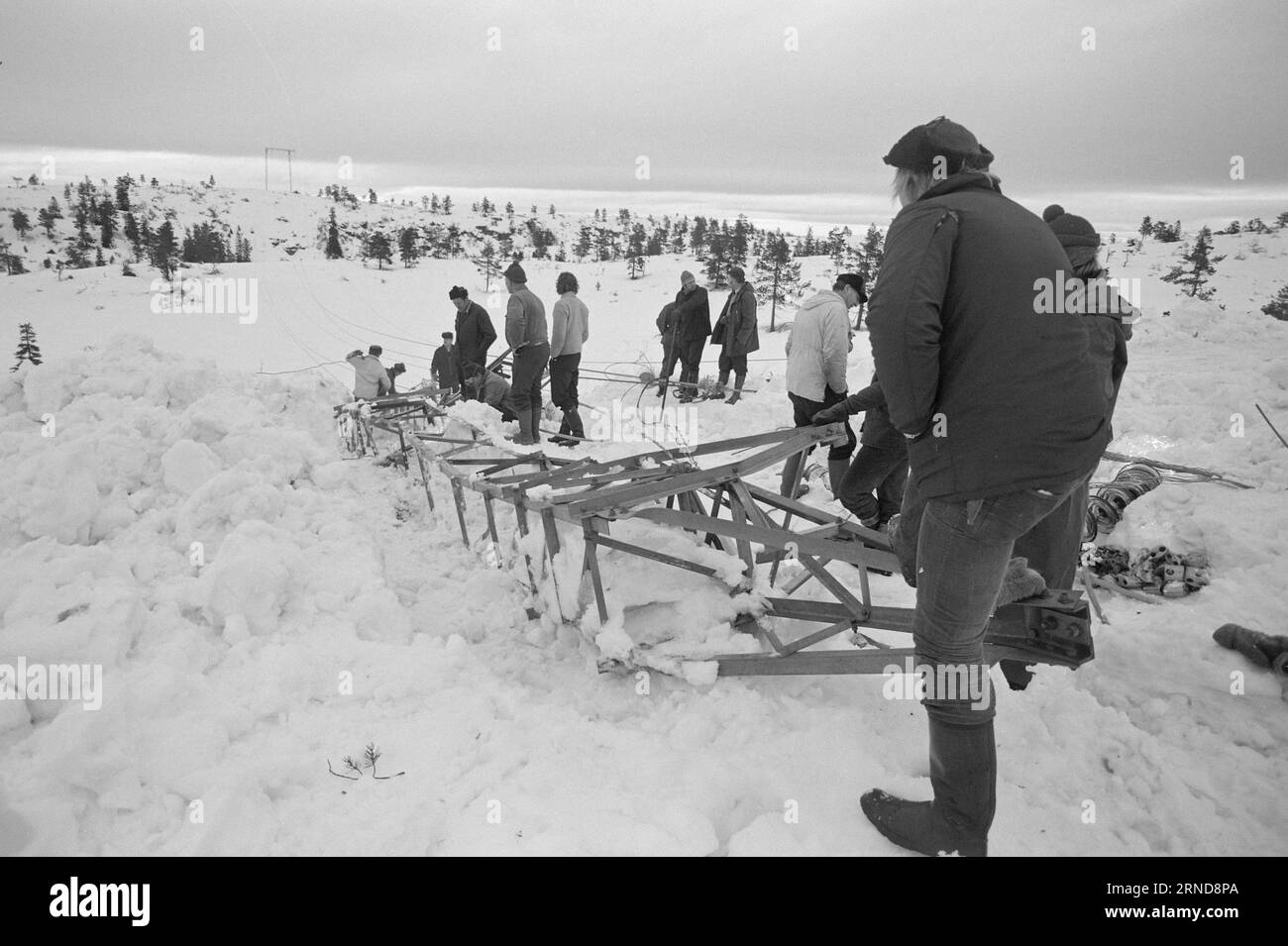 Actual 04 - 02 - 1974 : dur labeur dans la bruyère dans la nuit du 7 janvier, les dieux de la météo ont frappé dans le sud de la Norvège et ont fait des ravages sur le réseau électrique. Le plus touché a été la ligne Brokke dans les landes à l'est du Byglandsfjord. Ici, ce qui peut être sauvegardé est sauvegardé. Aujourd'hui, un hélicoptère transporte des poteaux et d'autres matériaux dans la montagne. Le travail prendra six semaines. Les gars sur la photo nettoient les épaves pour faire de la place pour de nouveaux postes. Photo : Sverre A. Børretzen / Aktuell / NTB ***PHOTO NON TRAITÉE*** ce texte a été traduit automatiquement! Banque D'Images