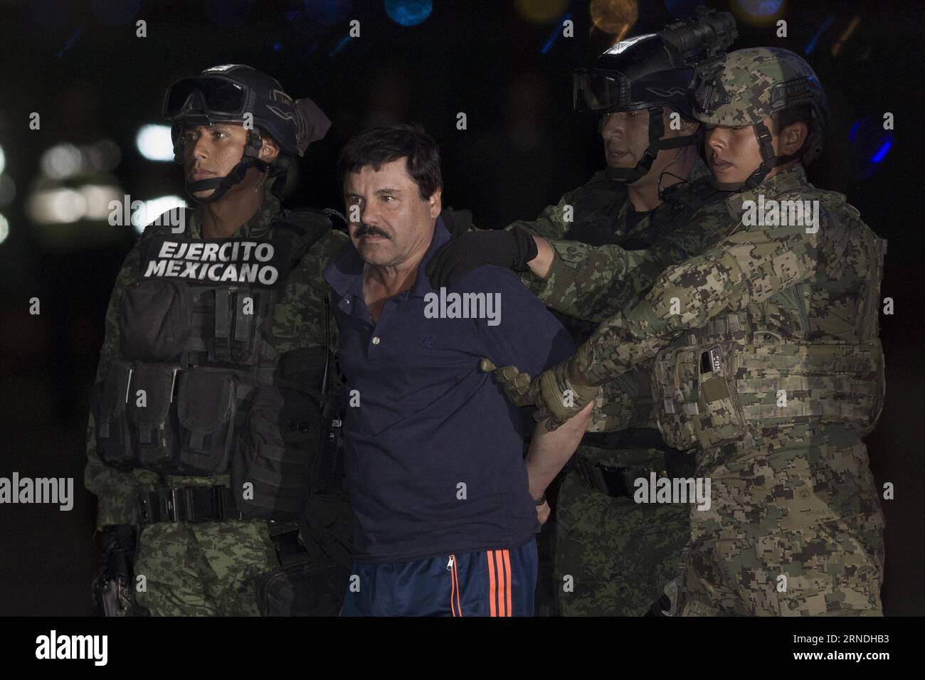 (160520) -- MEXICO, 20 mai 2016 -- une image prise le 8 janvier 2016 montre des membres des forces de sécurité escortant Joaquin Guzman Loera, alias El Chapo , à son arrivée au bureau du procureur général, à Mexico, capitale du Mexique. Le druglord mexicain Joaquin El Chapo Guzman doit être extradé vers les États-Unis, a annoncé vendredi le ministère des Affaires étrangères (SRE, pour son acronyme en espagnol). Le ministère a dit qu'il a informé Guzman, qui a récemment été transféré dans une prison près de la frontière américaine, qu'il avait approuvé une demande d'extradition déposée par un tribunal fédéral de district du Texas.) Banque D'Images