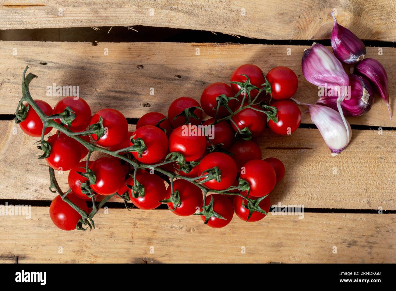 tomate cerise et ail pourpre cloveson fond en bois Banque D'Images