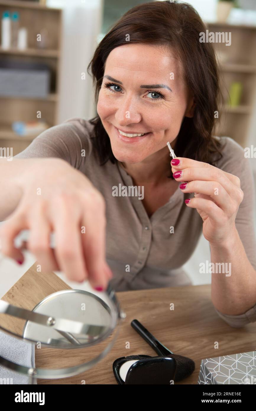 jeune femme enlevant les poils du visage Banque D'Images