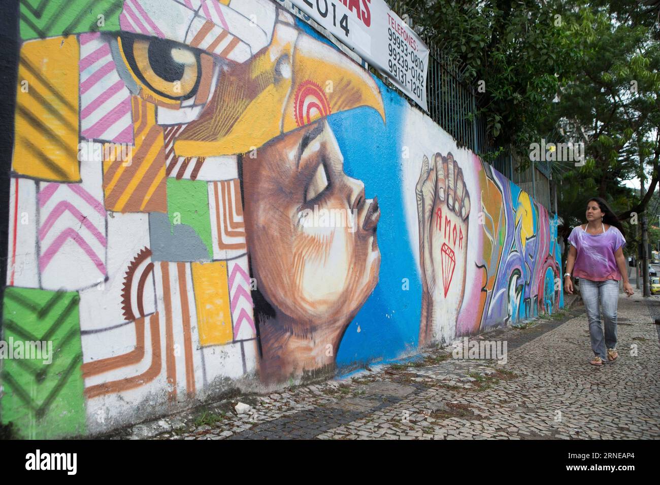 (160616) -- PÉKIN, 16 juin 2016 -- cette photo montre une dame qui passe devant un mur couvert de peintures murales et de graffitis à Rio de Janeiro, Brésil, le 23 mars 2014. Les Jeux Olympiques de Rio 2016 se tiendront du 5 au 21 août. )(wll) (SP)FILES-BRAZIL-RIO DE JANEIRO-OLYMPICS-CITY XuxZijian PUBLICATIONxNOTxINxCHN 160616 Beijing juin 16 2016 ce fichier photo montre une dame marchant devant un mur couvert de peintures murales et de graffitis à Rio de Janeiro Brésil LE 23 2014 mars, les Jeux Olympiques de Rio 2016 seront héros du 5 au 21 août SP fichiers Brésil Rio de Janeiro Olympics City XuxZijian PUBLICATIONxNOTx Banque D'Images
