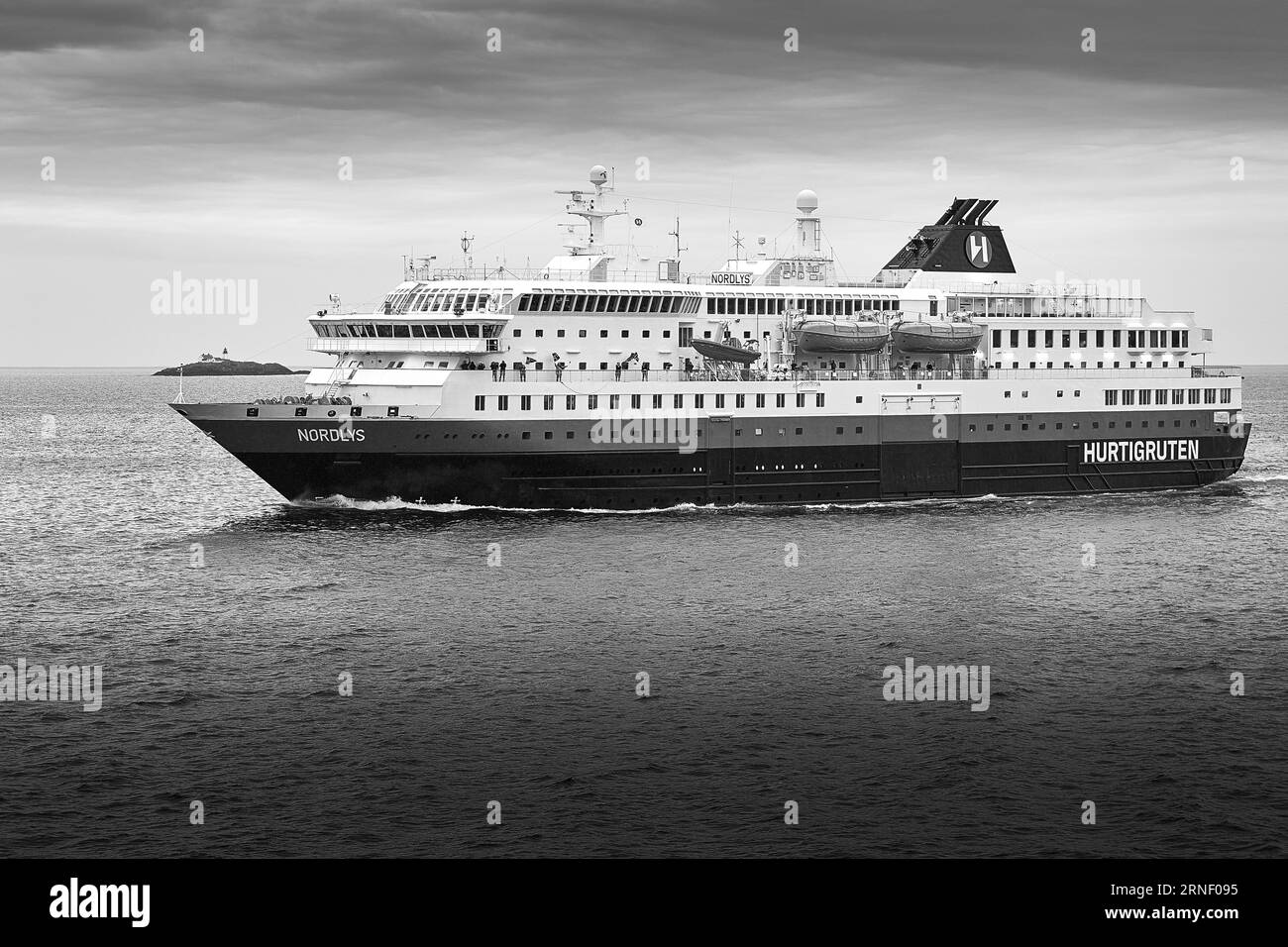 Photo en noir et blanc du Norwegian Hurtigruten Ferry MS NORDLYS, naviguant vers le nord dans le Vestfjorden, phare de Moholmen (Moholmen FYR) derrière Banque D'Images Photo en noir et blanc du Norwegian Hurtigruten Ferry MS NORDLYS, naviguant vers le nord dans le Vestfjorden, phare de Moholmen (Moholmen FYR) derrière Banque D'Images