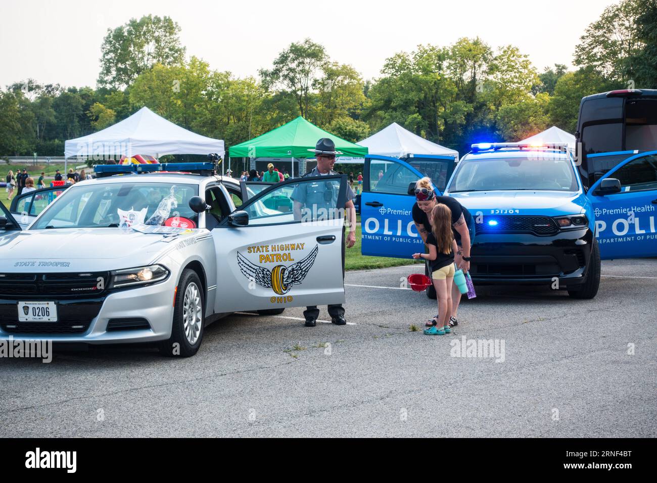 Enfant âgé de 7 ans en interaction avec un policier du State Trooper lors d'un événement d'engagement communautaire dans la ville de Beavercreek, Ohio, États-Unis Banque D'Images