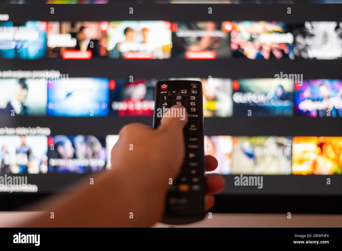 Personne méconnaissable se détendant à la maison en regardant la télévision. Afficher les services de streaming pour le divertissement à la télévision. Choix de séries TV et de films Banque D'Images