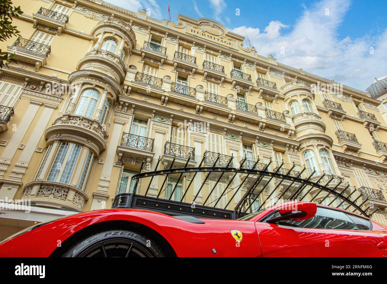 Une Ferrari rouge avec un cheval de lance jaune garé à l'extérieur de l'Hôtel Hermitage, Monte-Carlo, France Banque D'Images