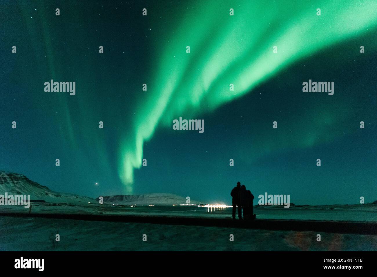 Quelques voyageurs étrangers observent les aurores boréales (aurora borealis) apparaître dans le ciel nocturne à Hvalfjörður près de Reykjavik, en Islande. Banque D'Images