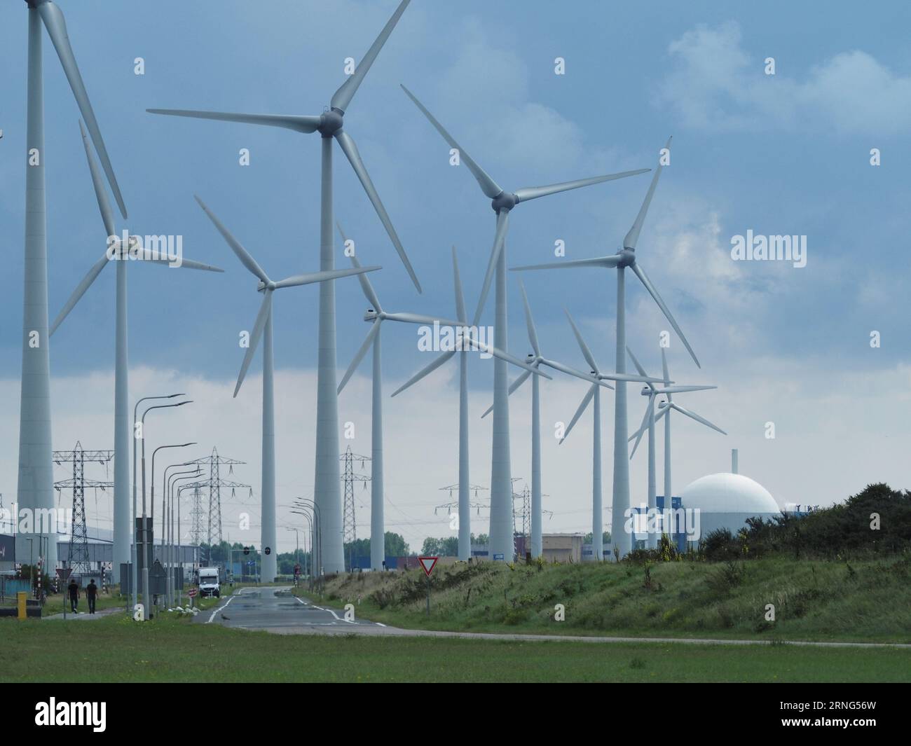 De nombreuses éoliennes le long de la côte à Borssele, Zeeland, pays-Bas, avec le dôme de la centrale nucléaire à côté d'eux. Banque D'Images