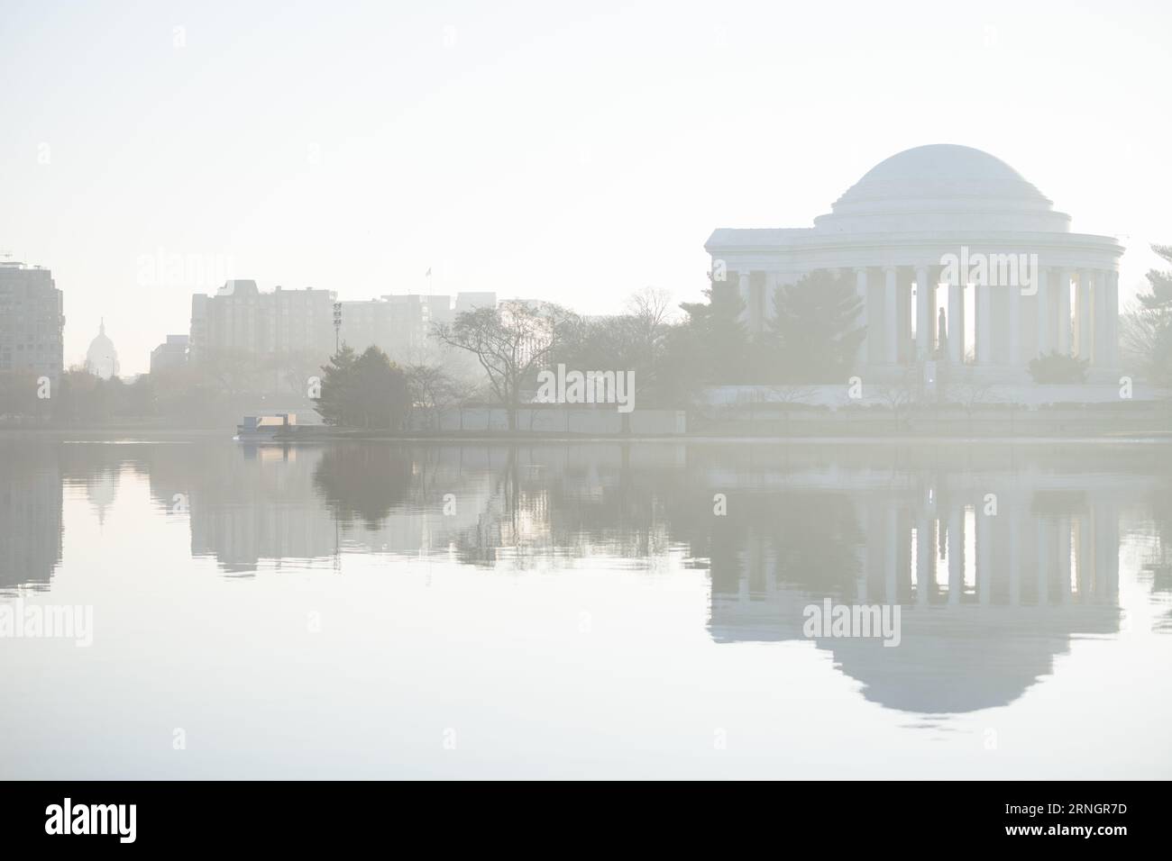 Jefferson Memorial reflété dans le bassin de Tidal Basin Washington DC // WASHINGTON DC — le Jefferson Memorial se reflète dans les eaux du bassin de Tidal Basin pendant un matin brumeux. Le monument néoclassique, dédié à Thomas Jefferson, troisième président des États-Unis et auteur principal de la Déclaration d'indépendance, a été achevé en 1943. La structure circulaire, conçue par l'architecte John Russell Pope, présente une statue en bronze de 5,8 mètres de long de Jefferson entourée d'extraits de ses écrits. Le Tidal Basin, une crique artificielle de 107 acres (43 hectares), fait partie du parc West Potomac Banque D'Images Jefferson Memorial reflété dans le bassin de Tidal Basin Washington DC // WASHINGTON DC — le Jefferson Memorial se reflète dans les eaux du bassin de Tidal Basin pendant un matin brumeux. Le monument néoclassique, dédié à Thomas Jefferson, troisième président des États-Unis et auteur principal de la Déclaration d'indépendance, a été achevé en 1943. La structure circulaire, conçue par l'architecte John Russell Pope, présente une statue en bronze de 5,8 mètres de long de Jefferson entourée d'extraits de ses écrits. Le Tidal Basin, une crique artificielle de 107 acres (43 hectares), fait partie du parc West Potomac Banque D'Images