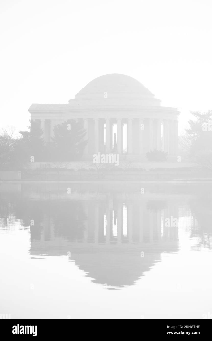 Jefferson Memorial reflété dans le bassin de Tidal Basin Washington DC // WASHINGTON DC — le Jefferson Memorial se reflète dans les eaux du bassin de Tidal Basin pendant un matin brumeux. Le monument néoclassique, dédié à Thomas Jefferson, troisième président des États-Unis et auteur principal de la Déclaration d'indépendance, a été achevé en 1943. La structure circulaire, conçue par l'architecte John Russell Pope, présente une statue en bronze de 5,8 mètres de long de Jefferson entourée d'extraits de ses écrits. Le Tidal Basin, une crique artificielle de 107 acres (43 hectares), fait partie du parc West Potomac Banque D'Images Jefferson Memorial reflété dans le bassin de Tidal Basin Washington DC // WASHINGTON DC — le Jefferson Memorial se reflète dans les eaux du bassin de Tidal Basin pendant un matin brumeux. Le monument néoclassique, dédié à Thomas Jefferson, troisième président des États-Unis et auteur principal de la Déclaration d'indépendance, a été achevé en 1943. La structure circulaire, conçue par l'architecte John Russell Pope, présente une statue en bronze de 5,8 mètres de long de Jefferson entourée d'extraits de ses écrits. Le Tidal Basin, une crique artificielle de 107 acres (43 hectares), fait partie du parc West Potomac Banque D'Images