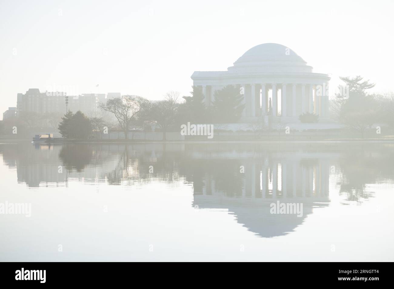 Jefferson Memorial reflété dans le bassin de Tidal Basin Washington DC // WASHINGTON DC — le Jefferson Memorial se reflète dans les eaux du bassin de Tidal Basin pendant un matin brumeux. Le monument néoclassique, dédié à Thomas Jefferson, troisième président des États-Unis et auteur principal de la Déclaration d'indépendance, a été achevé en 1943. La structure circulaire, conçue par l'architecte John Russell Pope, présente une statue en bronze de 5,8 mètres de long de Jefferson entourée d'extraits de ses écrits. Le Tidal Basin, une crique artificielle de 107 acres (43 hectares), fait partie du parc West Potomac Banque D'Images Jefferson Memorial reflété dans le bassin de Tidal Basin Washington DC // WASHINGTON DC — le Jefferson Memorial se reflète dans les eaux du bassin de Tidal Basin pendant un matin brumeux. Le monument néoclassique, dédié à Thomas Jefferson, troisième président des États-Unis et auteur principal de la Déclaration d'indépendance, a été achevé en 1943. La structure circulaire, conçue par l'architecte John Russell Pope, présente une statue en bronze de 5,8 mètres de long de Jefferson entourée d'extraits de ses écrits. Le Tidal Basin, une crique artificielle de 107 acres (43 hectares), fait partie du parc West Potomac Banque D'Images