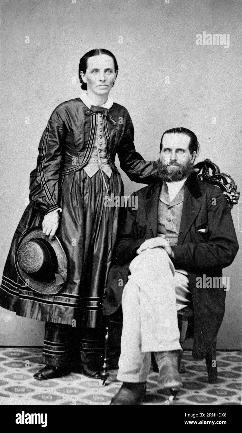 Photographie carte de visite, vers 1860, d'une femme vêtue d'une robe fleurie et de son mari barbu prise dans un studio de photographie américain. Banque D'Images