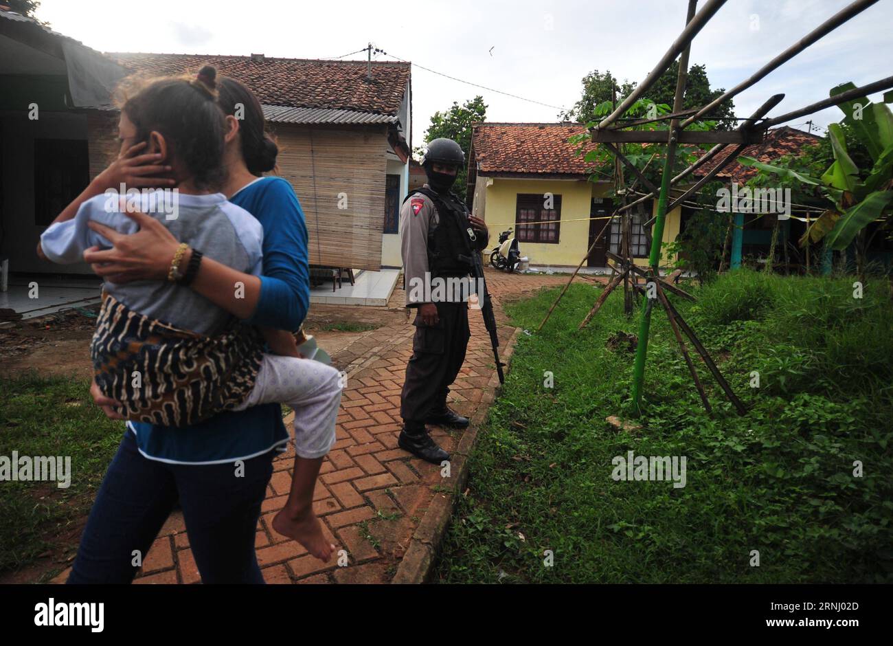 Indonésien : Terror-Razzia nahe der Hauptstadt Jakarta (161221) -- TANGERANG (INDONÉSIE), 21 décembre 2016 -- Une femme portant son enfant passe devant un policier debout près du site où les forces de police ont abattu des militants présumés à Tangerang, dans la province de Banten, en Indonésie, le 21 décembre 2016. L'équipe anti-terroriste indonésienne a abattu mercredi trois militants présumés, en a capturé un autre et saisi une grosse bombe active lors d'une fusillade et d'un raid dans une ville périphérique de Jakarta, a déclaré la police ici. ) (Sxk) INDONESIA-TANGERANG-MILITANTS-FORCES DE L'ORDRE Zulkarnain PUBLICATIONxNOTxINxCHN Indonesia Terror Ra Banque D'Images