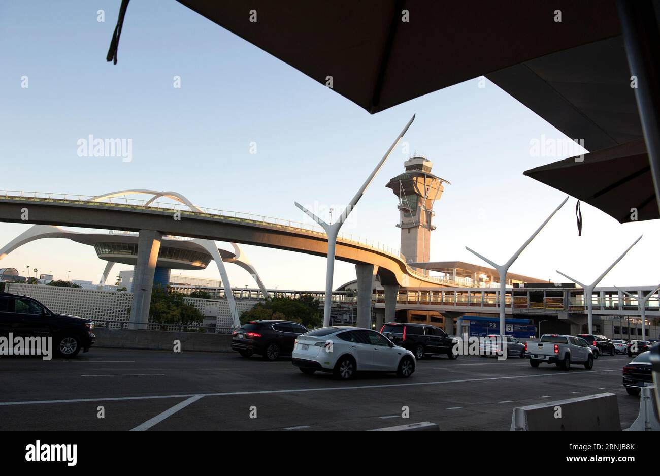 Une nouvelle voie ferrée de métro entrant dans LAX obscurcit partiellement la vue de l'emblématique Theme Building, Los Angeles, Californie, États-Unis Banque D'Images
