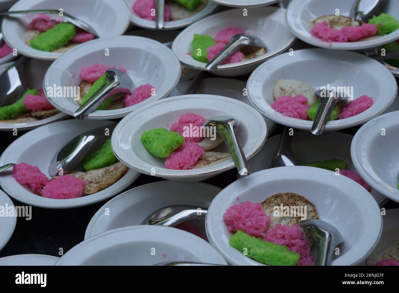 Dawet serabi pour les acheteurs sur un marché traditionnel. C'est la nourriture traditionnelle javanaise de brins de farine de riz enroulés en boule ; mangé avec du lait de coco A. Banque D'Images