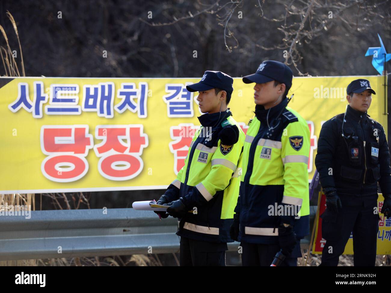 (170314) -- SEONGJU, 14 mars 2017 -- des policiers se tiennent devant une bannière anti-THAAD à l'entrée du site de déploiement de la défense régionale terminale à haute altitude (THAAD) dans le comté de Seongju, province du Gyeongsang du Nord, Corée du Sud, le 14 mars 2017. La route d ' entrée du terrain de golf où le THAAD doit être déployé a été bloquée par une brigade de policiers qui interdit à quiconque de s ' approcher du site THAAD. ) (wtc) CORÉE DU SUD-SEONGJU-THAAD DEPLOIEMENT-SECURITY LiuxYun PUBLICATIONxNOTxINxCHN 170314 Seongju Mars 14 2017 les policiers se tiennent devant la bannière anti THAAD À l'entrée du Banque D'Images