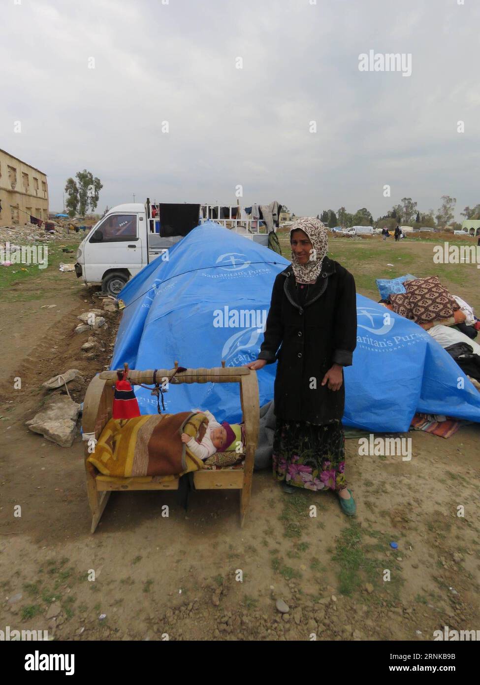 (170320) -- MOSSOUL, 19 mars 2017 -- Une femme s'occupe de son fils de six mois au camp de hammam Aleel, en Irak, le 19 mars 2017. À environ 20 km au sud de Mossoul, le camp de hammam Aleel est une plaque tournante importante pour les civils de Mossoul qui doivent être déplacés. Selon un responsable du camp, plus de 35 000 personnes vivaient ici au plus fort, et environ 10 000 personnes sont relocalisées ici à l'heure actuelle.) (dtf) IRAK-MOSSOUL-HAMMAM ALEEL CAMP-RÉFUGIÉS KhalilxDawood PUBLICATIONxNOTxINxCHN Mossoul Mars 19 2017 une femme prend soin de son vieux soleil de six mois AU camp hammam Irak LE 19 2017 mars À environ 20 km au sud de Mossoul hammam Cam Banque D'Images