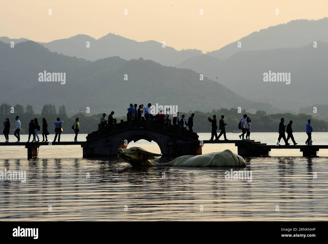 (170413) -- HANGZHOU, 13 avril 2017 -- les gens marchent sur un pont au coucher du soleil au lac de l'Ouest à Hangzhou, capitale de la province du Zhejiang de l'est de la Chine, 13 avril 2017.) (dhf) CHINE-HANGZHOU-WEST LAKE-SUNSET (CN) HanxChuanhao PUBLICATIONxNOTxINxCHN Hangzhou avril 13 2017 célébrités marchent SUR un pont AU coucher du soleil AU lac de l'OUEST à Hangzhou capitale de l'est de la Chine S Zhejiang province avril 13 2017 DHF Chine Hangzhou WEST Lake Sunset CN HanxChuanhao PUBLICATIONxNOTxINxCHN Banque D'Images