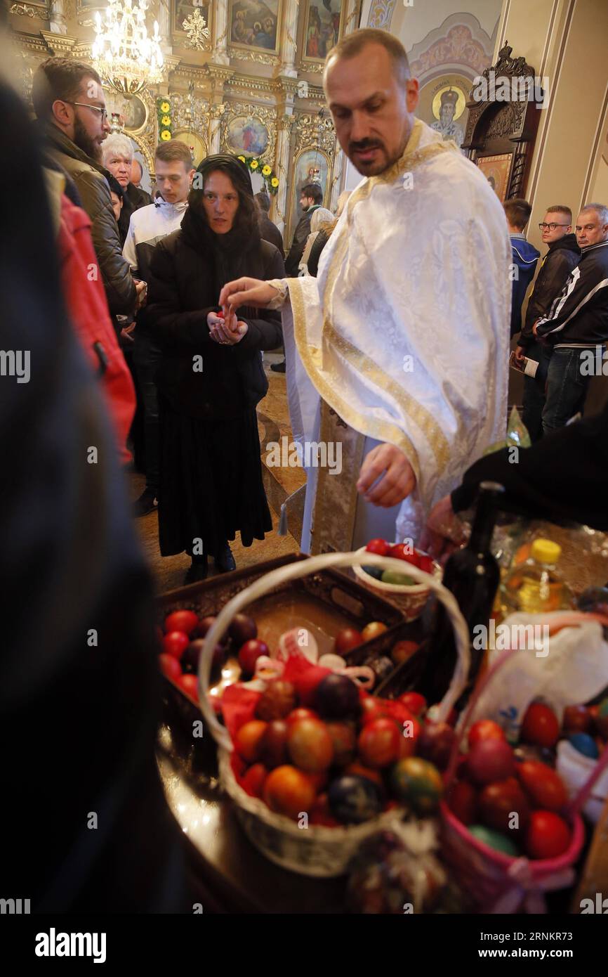 (170416) -- SVILAJNAC, 16 avril 2017 -- un prêtre orthodoxe serbe partage des oeufs de Pâques avec des fidèles comme symbole de la résurrection de Jésus-Christ, lors d'une messe de Pâques dans l'église St Nikola de la ville de Svilajnac, dans l'est de la Serbie, le 16 avril 2017. Les Serbes orthodoxes observent Pâques selon l'ancien calendrier Julien qui tombe cette année le 16 avril. (yk) SERBIE-SVILAJNAC-MESSE DE PÂQUES PredragxMilosavljevic PUBLICATIONxNOTxINxCHN avril 16 2017 le prêtre orthodoxe serbe partage des oeufs de Pâques avec le vénérable comme symbole de la résurrection de Jésus-Christ pendant la messe de Pâques dans l'église St Nikola Banque D'Images