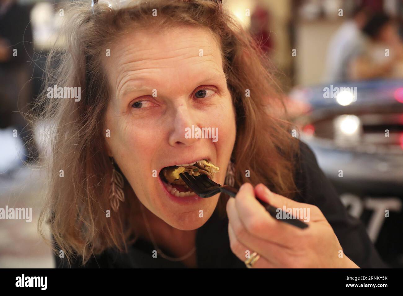 (170425) -- NEW YORK, le 25 avril 2017 -- Un client mange le Jianbing de M. Bing dans l'aire de restauration UrbanSpace à New York, aux États-Unis, le 17 avril 2017. UrbanSpace à Midtown New York est un endroit où les cols blancs viennent déjeuner pendant leurs journées de travail. Depuis quelques mois, les clients font toujours la queue devant un kiosque sous une bannière avec des caractères chinois. Ce que ce kiosque vend est une nourriture chinoise très authentique dans le nord de la Chine -- Jianbing, ou la crêpe chinoise. Le kiosque porte la marque MR. Bing et appartient à Brian Goldberg, qui est né et a grandi à New York. Goldberg est très impliqué avec le chinois Banque D'Images