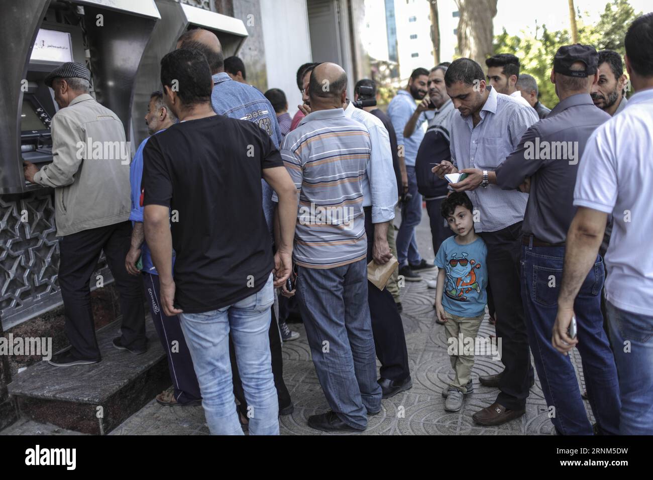 (170510) -- GAZA, 10 mai 2017 -- des Palestiniens employés par l'Autorité nationale palestinienne (ANP) attendent de recevoir leurs salaires d'un guichet automatique situé à l'extérieur d'une banque de la ville de Gaza, le 10 mai 2017. Les salaires des fonctionnaires palestiniens et des anciens agents de sécurité dans la bande de Gaza ont été réduits d'environ 30 pour cent pour le deuxième mois consécutif depuis que le gouvernement de consensus de l'Autorité nationale palestinienne (ANP) a pris la décision à Ramallah le 4 avril. MIDEAST-GAZA-PNA-EMPLOYEURS-RÉDUCTION DES SALAIRES-WissamxNassar PUBLICATIONxNOTxINxCHN Gaza Mai 10 2017 PALESTINIENS employés par les PALES Banque D'Images