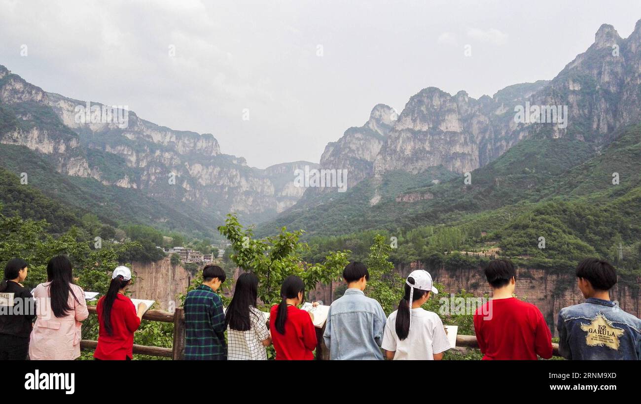 (170518) -- ZHENGZHOU, 18 mai 2017 -- des étudiants peignent sur une plate-forme touristique dans le village de Guoliang, Huixian, province du Henan, au centre de la Chine, le 17 mai 2017. Le couloir de la falaise de Guoliang est une route de 1 250 mètres de long construite le long de la falaise. La construction de cette route miraculeuse a duré cinq ans, de 1972 à 1977, et a été construite purement à la main par les villageois du village de Guoliang. Grâce à cette route, les villageois ici rejettent la pauvreté. ) (lfj) CHINA-HENAN-GUOLIANG VILLAGE-FALAISE ROAD (CN) ZhangxFengguo PUBLICATIONxNOTxINxCHN Zhengzhou Mai 18 2017 étudiants peignent SUR une plate-forme touristique à Guoliang Vill Banque D'Images