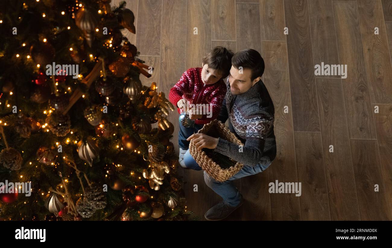 Heureux jeune père et petit fils décorant l'arbre de Noël. Banque D'Images