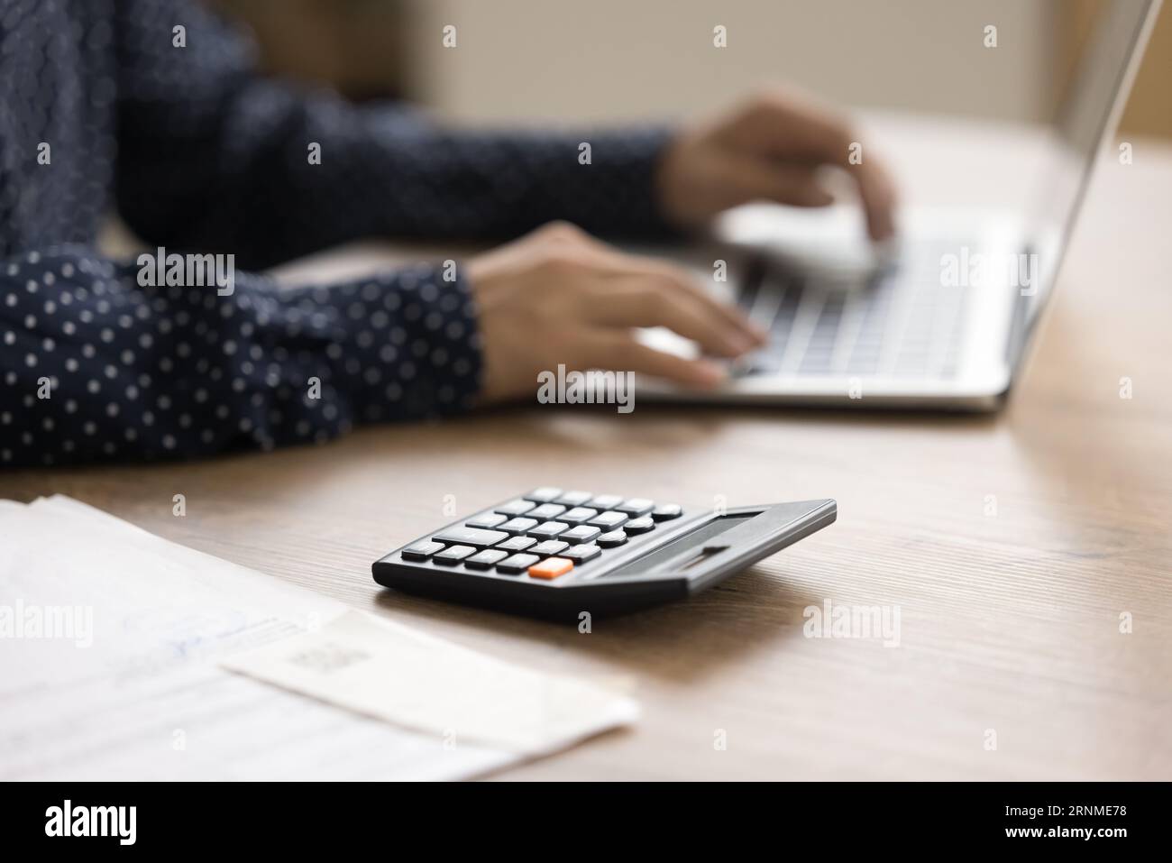 Calculatrice sur la surface de la table et vue rognée des mains féminines Banque D'Images