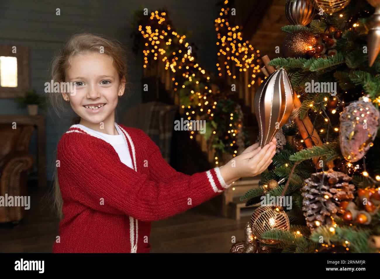 Portrait de petite fille mignonne heureuse décorant l'arbre de Noël. Banque D'Images