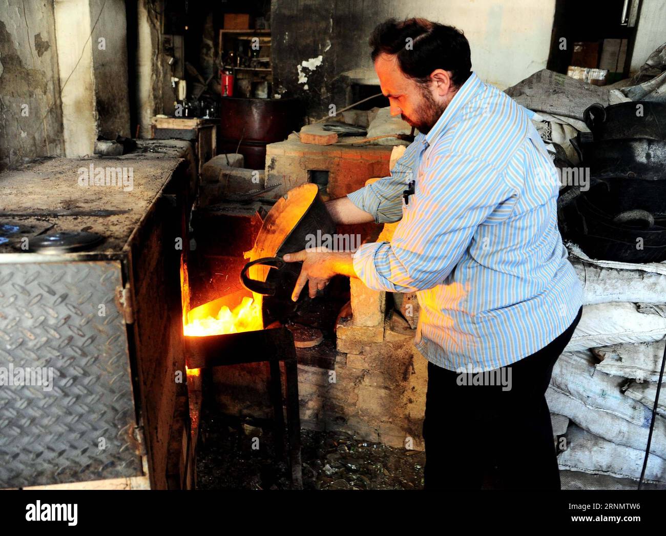 (170611) -- DAMAS, 11 juin 2017 -- Un souffleur de verre syrien met du verre fondu dans un four de son atelier de Damas, capitale de la Syrie, le 11 juin 2017. En utilisant une technique développée d'abord par les Phéniciens il y a environ 2 000 ans, les souffleurs de verre façonnent le verre fondu dans un four pour créer la verrerie traditionnelle populaire à Damas. SYRIE-DAMAS-FABRICATION TRADITIONNELLE DE VERRE AmmarxSafarjalani PUBLICATIONxNOTxINxCHN 170611 Damas juin 11 2017 un souffleur de verre syrien met du verre fondu dans LE FOUR DE son atelier à Damas capitale de la Syrie LE 11 2017 juin en utilisant une technique développée d'abord par Phoenici Banque D'Images