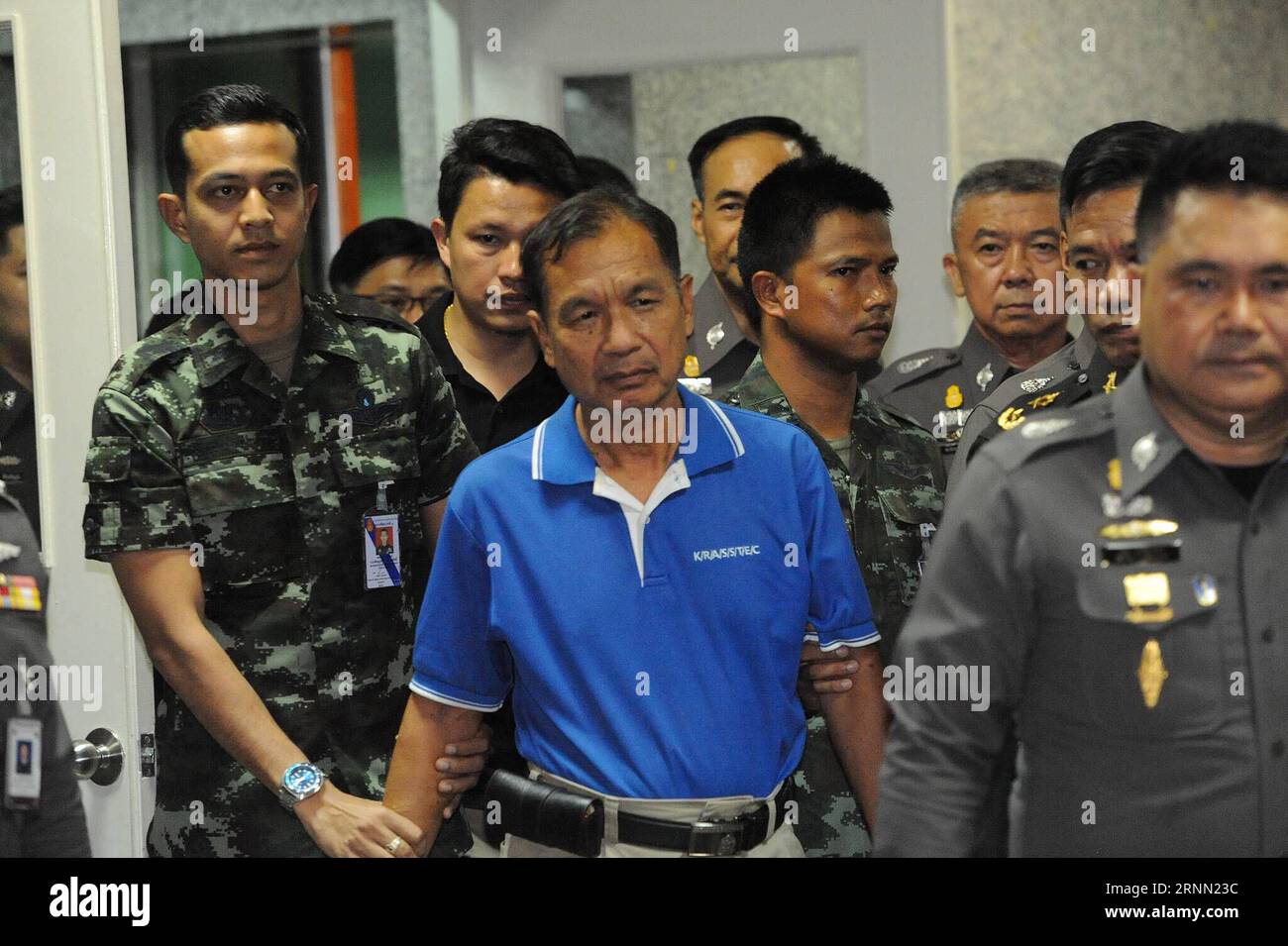 (170620) -- BANGKOK, 20 juin 2017 -- Watana Pumret (en chemise bleue), soupçonnée d'avoir attaqué l'hôpital militaire Phramongkutklao, est escortée par des soldats et des policiers thaïlandais au quartier général de la police royale thaïlandaise pour une conférence de presse à Bangkok, Thaïlande, le 20 juin 2017. Watana a été arrêté par la police thaïlandaise le 14 juin comme suspect pour l'attentat à la bombe dans un hôpital militaire de Bangkok qui avait blessé plus de 20 personnes le 22 mai, ce qui coïncidait avec le troisième anniversaire du coup d'État qui a accordé le pouvoir à la junte au pouvoir. RH) CONFERENC THAÏLANDE-BANGKOK-HÔPITAL-BOMBARDEMENT-SUSPECT-PRESSE Banque D'Images