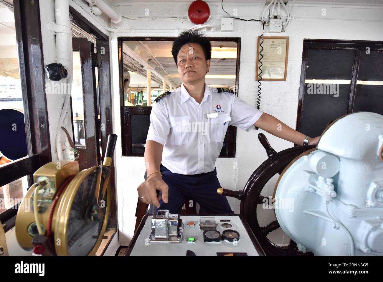 (170623) -- HONG KONG, le 23 juin 2017 -- le capitaine navigue sur le Star Ferry sur la route reliant WAN Chai et Tsim Sha Tsui à Hong Kong, dans le sud de la Chine, le 13 juin 2017. Le 1 juillet 2017 marque le 20e anniversaire du retour de Hong Kong à la mère patrie. (Ry) CHINA-HONG KONG-RETURN ANNIVERSARY-STAR FERRY (CN) WangxXi PUBLICATIONxNOTxINxCHN Hong Kong juin 23 2017 le capitaine NAVIGUE SUR le Star Ferry SUR la route reliant WAN Chai et Tsim Sha Tsui à Hong Kong Chine méridionale juin 13 2017 juillet 1 2017 marque le 20e anniversaire du retour de Hong Kong S. The Motherland Ry Chine Hong Kong Return Anniversary Star F Banque D'Images