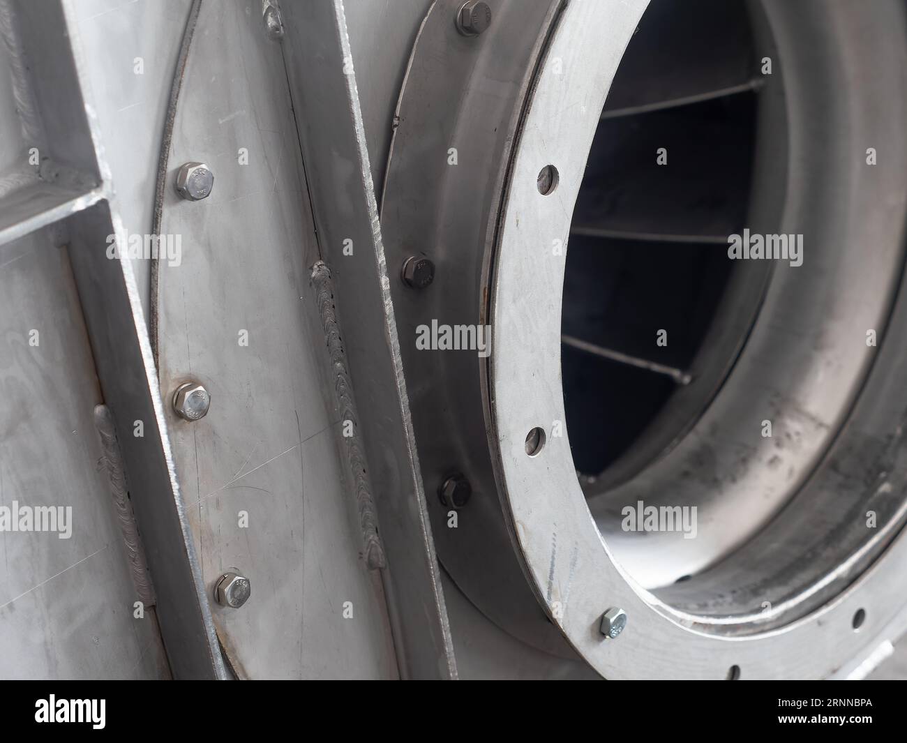 Gros plan détail du ventilateur centrifuge en acier inoxydable pendant la production dans un atelier industriel. Logement principalement mis au point, rotor hors de mise au point. Banque D'Images