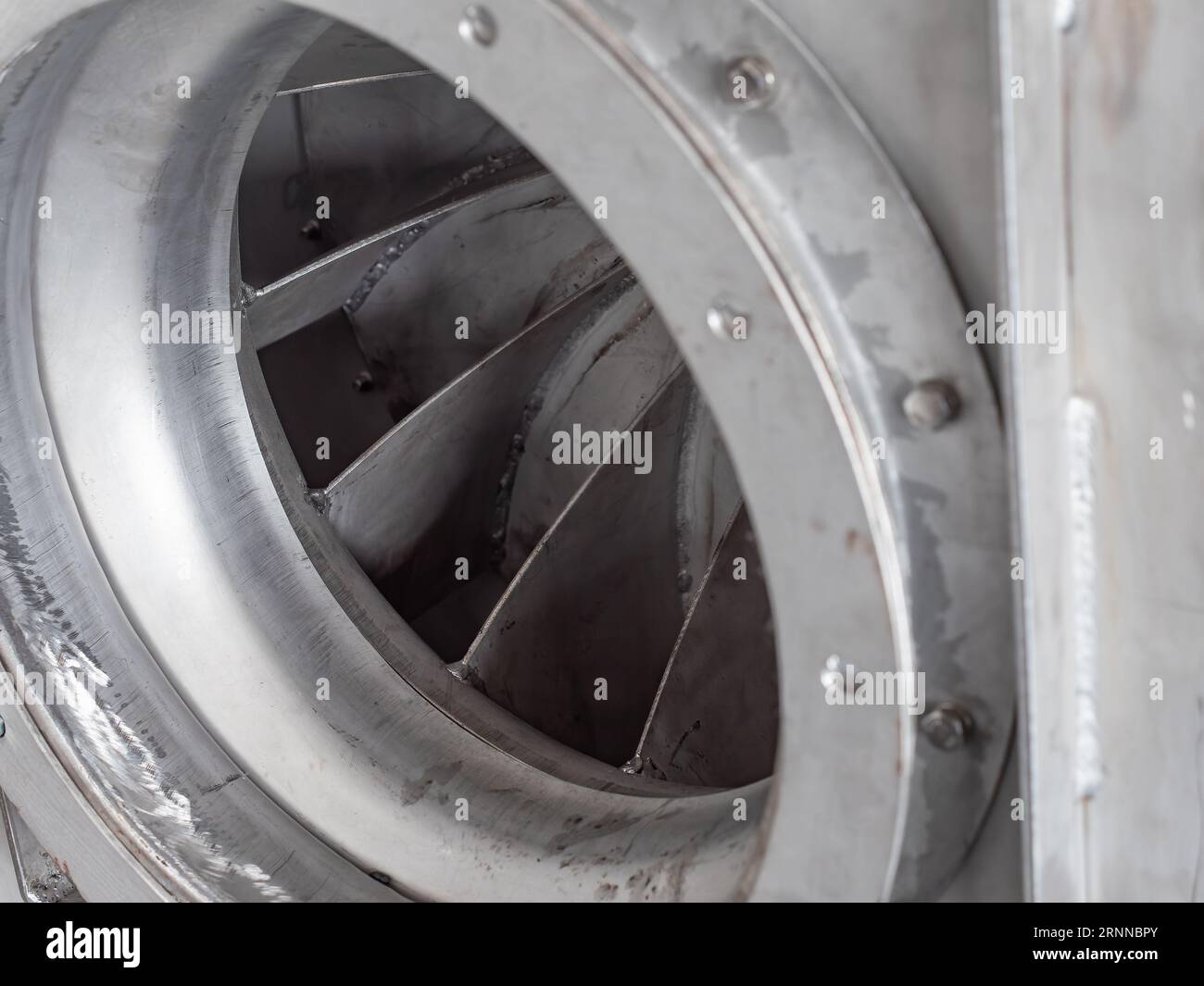 Gros plan détail du ventilateur centrifuge en acier inoxydable pendant la production dans un atelier industriel. Faible profondeur de champ avec des parties de la pale de la turbine Banque D'Images