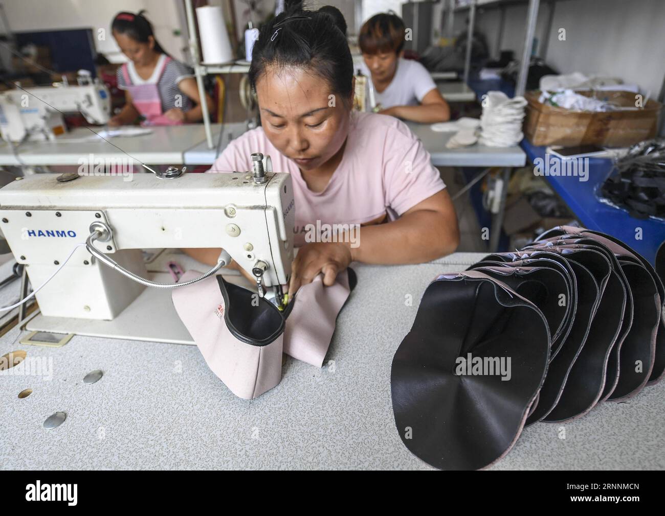 (170721) -- FUCHENG, le 21 juillet 2017 -- Une femme fabrique une chaussure dans un atelier du village de Cuiyangzhuang de la ville de Wangjixiang, comté de Fucheng dans la province du Hebei du nord de la Chine, le 20 juillet 2017. Plus de 1 000 femmes laissées pour compte qui restent dans la ville pendant que leurs maris travaillent dans d ' autres villes sont organisées ces dernières années pour participer à la production de chaussures en tissu fabriquées à la main qui apportent à chacune un revenu moyen de 30 000 yuans par an. (clq) CHINE-HEBEI-FUCHENG-VILLAGE-FEMMES-SOULAGEMENT DE LA PAUVRETÉ(CN) LixXiaoguo PUBLICATIONxNOTxINxCHN Fucheng juillet 21 2017 une femme fabrique une chaussure dans un atelier à Villag Banque D'Images