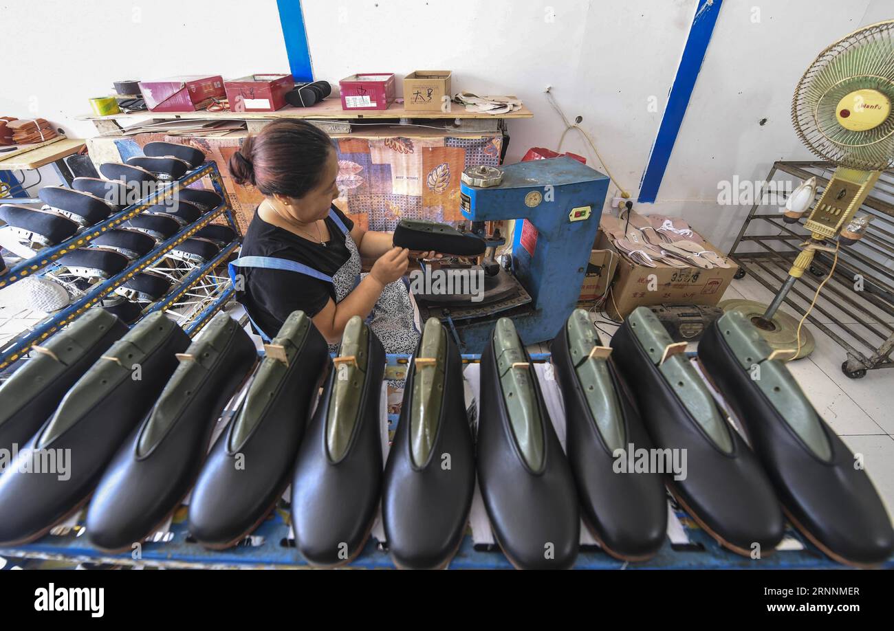 (170721) -- FUCHENG, le 21 juillet 2017 -- Une femme fabrique une chaussure dans un atelier du village de Cuiyangzhuang de la ville de Wangjixiang, comté de Fucheng dans la province du Hebei du nord de la Chine, le 20 juillet 2017. Plus de 1 000 femmes laissées pour compte qui restent dans la ville pendant que leurs maris travaillent dans d ' autres villes sont organisées ces dernières années pour participer à la production de chaussures en tissu fabriquées à la main qui apportent à chacune un revenu moyen de 30 000 yuans par an. (clq) CHINE-HEBEI-FUCHENG-VILLAGE-FEMMES-SOULAGEMENT DE LA PAUVRETÉ(CN) LixXiaoguo PUBLICATIONxNOTxINxCHN Fucheng juillet 21 2017 une femme fabrique une chaussure dans un atelier à Villag Banque D'Images
