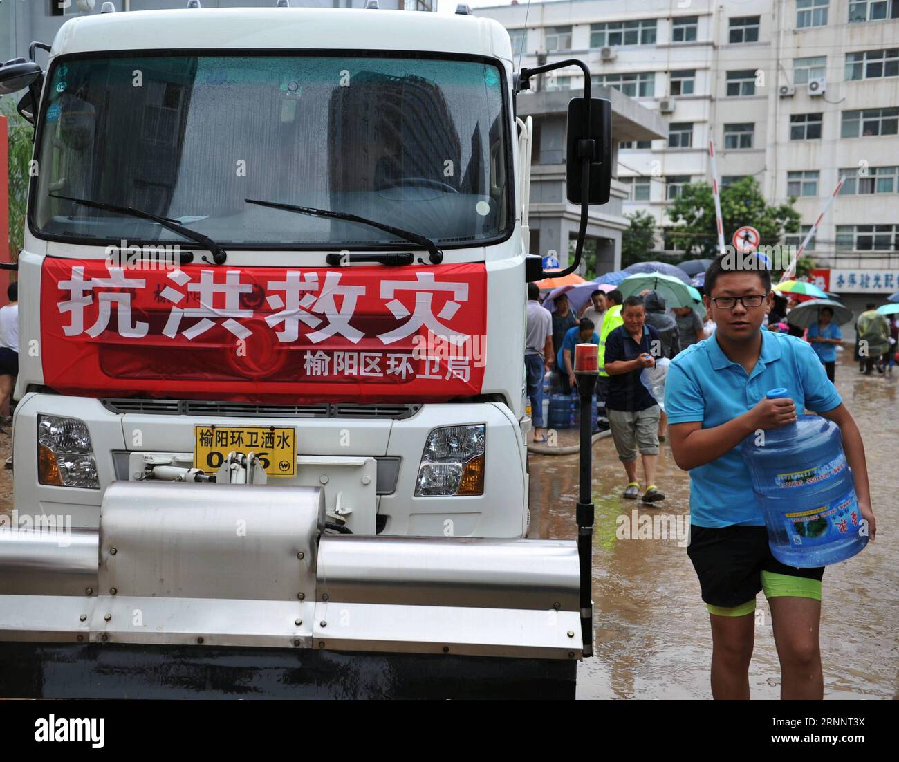 (170727) -- YULIN, 27 juillet 2017 -- Un homme reçoit un pot d'eau potable d'une station de distribution d'eau dans le comté de Suide de la ville de Yulin, dans la province du Shaanxi au nord-ouest de la Chine, le 27 juillet 2017. Les travaux de sauvetage se poursuivent dans les comtés de Suide et Zizhou les plus touchés après une pluie torrentielle qui a provoqué une inondation dans la ville. (clq) CHINA-SHAANXI-YULIN-FLOOD-RESCUE(CN) ZhangxBowen PUBLICATIONxNOTxINxCHN Yulin juillet 27 2017 un homme REÇOIT un pot d'eau potable d'une station de distribution d'eau dans le comté de suid City Nord-Ouest de la Chine S Shaanxi province juillet 27 2017 le travail de sauvetage se poursuit dans le suide et Banque D'Images