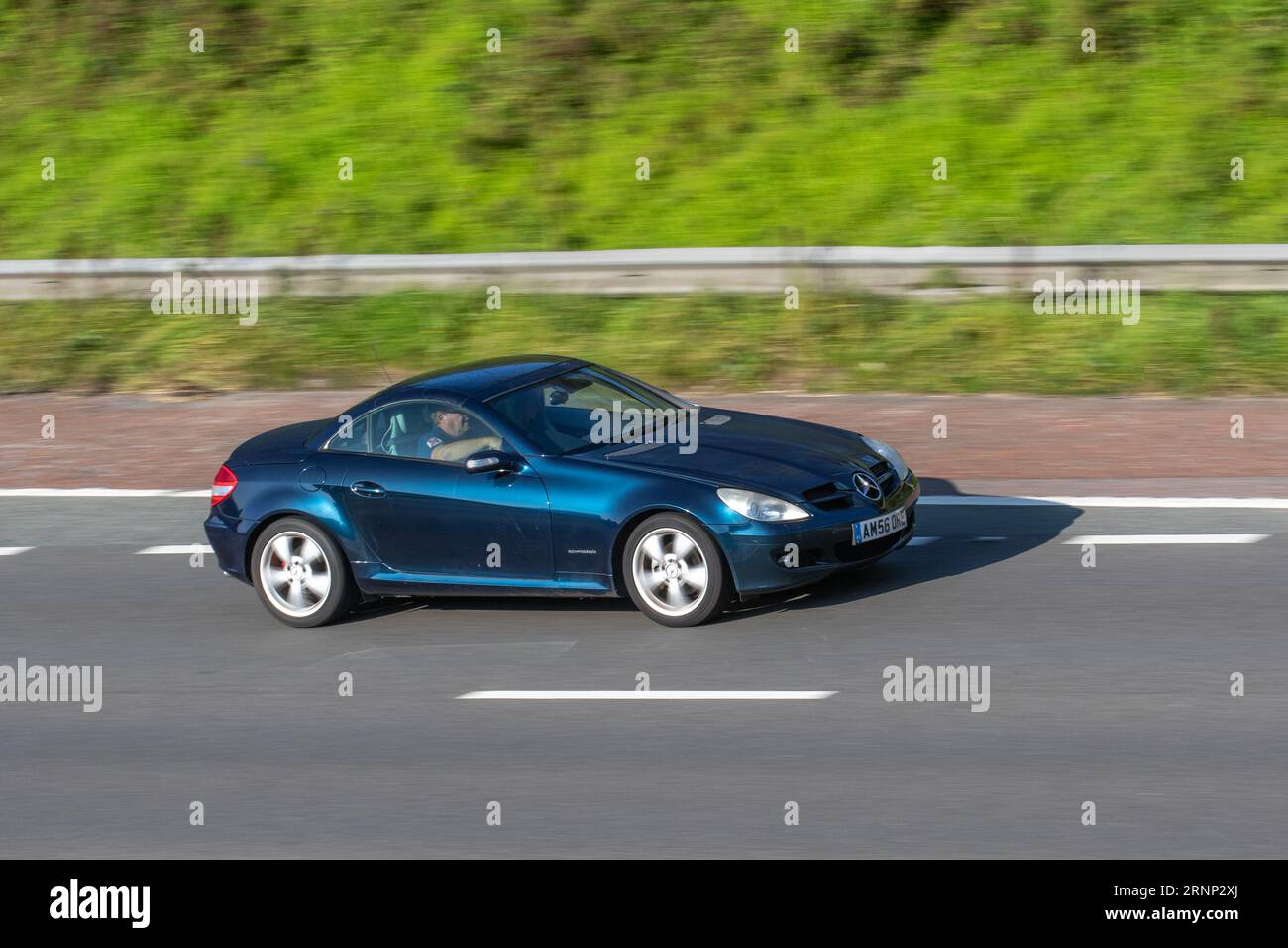 2006 Bleu Mercedes-Benz SLK 200 Kompressor Auto se déplaçant à grande vitesse sur l'autoroute M6 dans le Grand Manchester, Royaume-Uni Banque D'Images