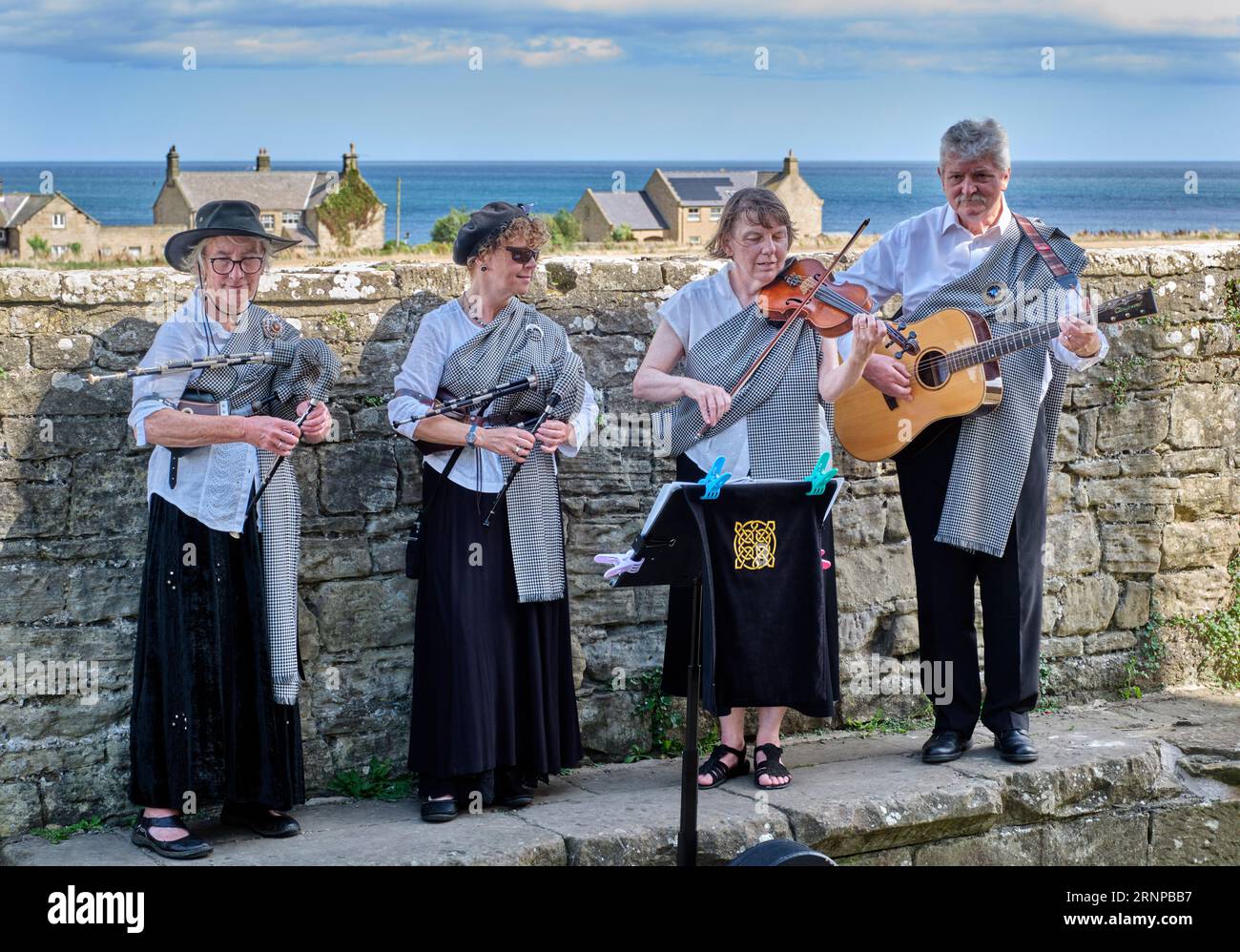 Un groupe avec deux femmes jouant des petites pipes de Northumbrian, aussi de l'alto et de la guitare. Cresswell, Northumberland, Angleterre. Banque D'Images