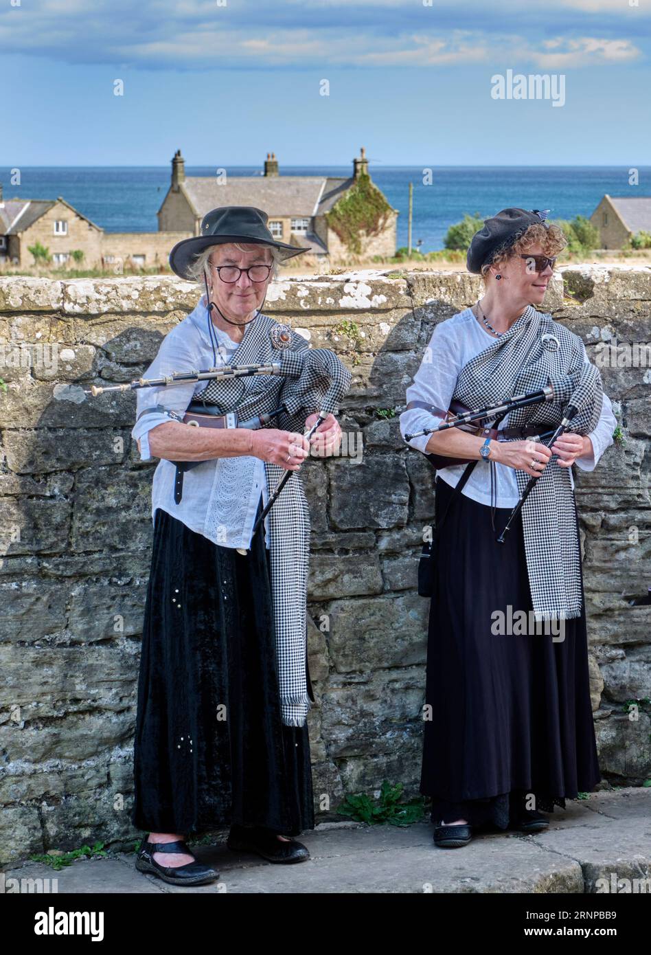 Deux femmes jouant aux petites pipes de Northumbrian. Cresswell, Northumberland, Angleterre. Banque D'Images