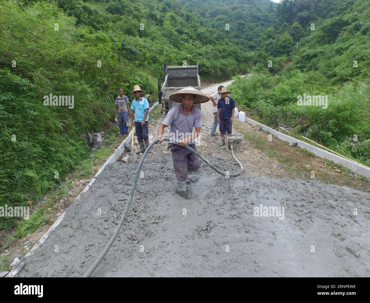 (170826) -- RONG AN, 26 août 2017 -- des villageois construisent une route ruale dans le village de Tongban du comté de Rong an, dans la région autonome de Guangxi Zhuang, dans le sud de la Chine, le 22 juillet 2015. Tongban Village est situé dans une zone montagneuse du Guangxi. Le travailleur migrant de 50 ans, long Gexiong, a choisi de rester dans sa ville natale de Tongban après la fête du printemps en 2012. Il lance un projet de développement de sa ville natale et établit une coopérative avec ses cousins. Ils ont planté des pruniers et des raisins et ont fait des affaires touristiques avec le capital initial qu'ils gagnaient en tant que travailleurs migrants. Bien qu'ils aient rencontré de nombreuses difficultés à Banque D'Images