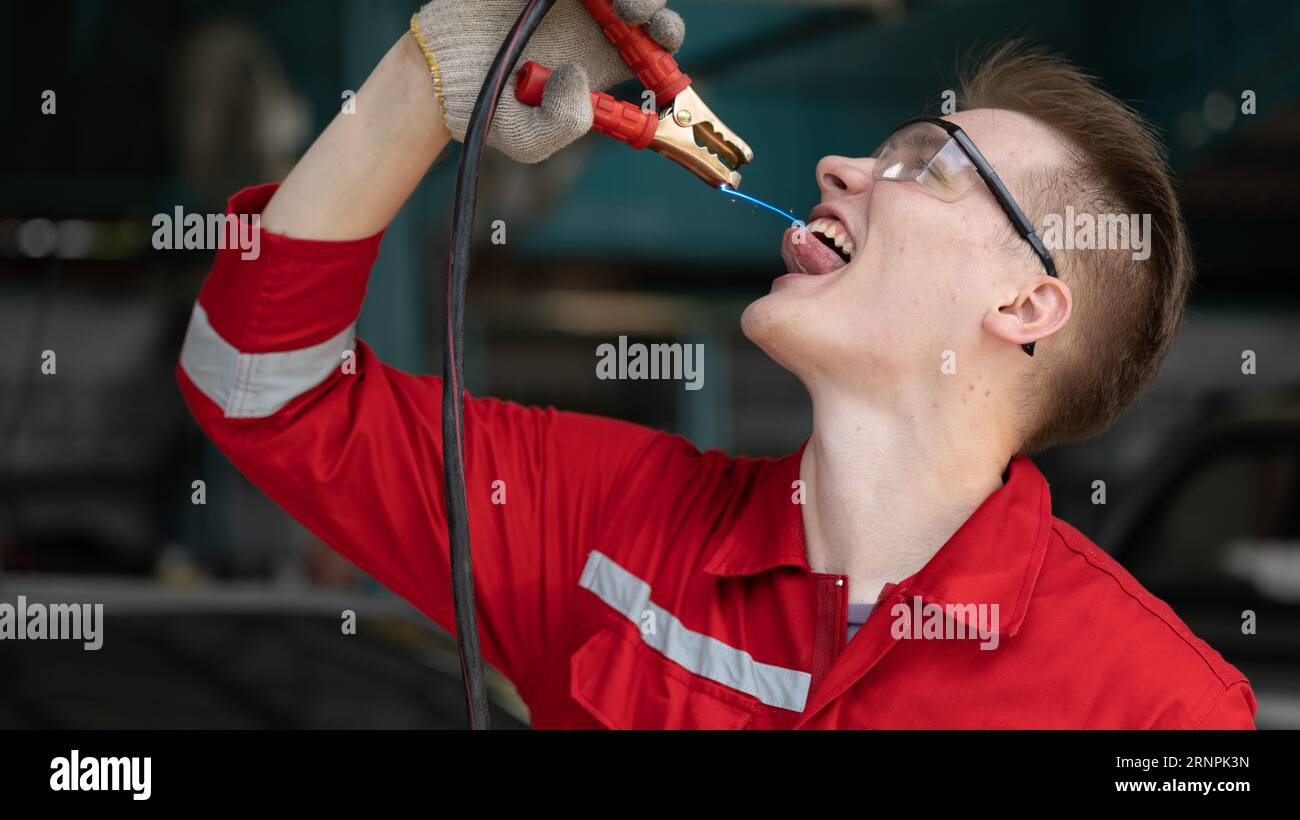 Homme d'électricité masculin mécanicien avec la langue de clip d'outil de pinces de batterie de charge pour charger l'homme puissant d'auto-énergie de corps Banque D'Images
